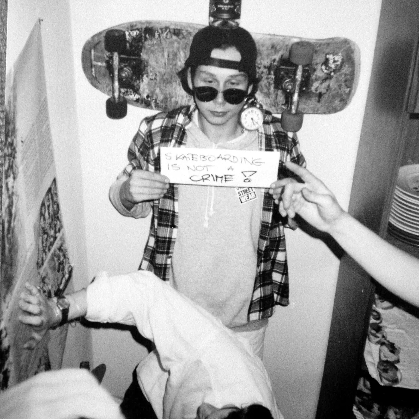 Archiwalne zdjęcie: skater z napisem Skateboarding is not a crime, za nim stara deska